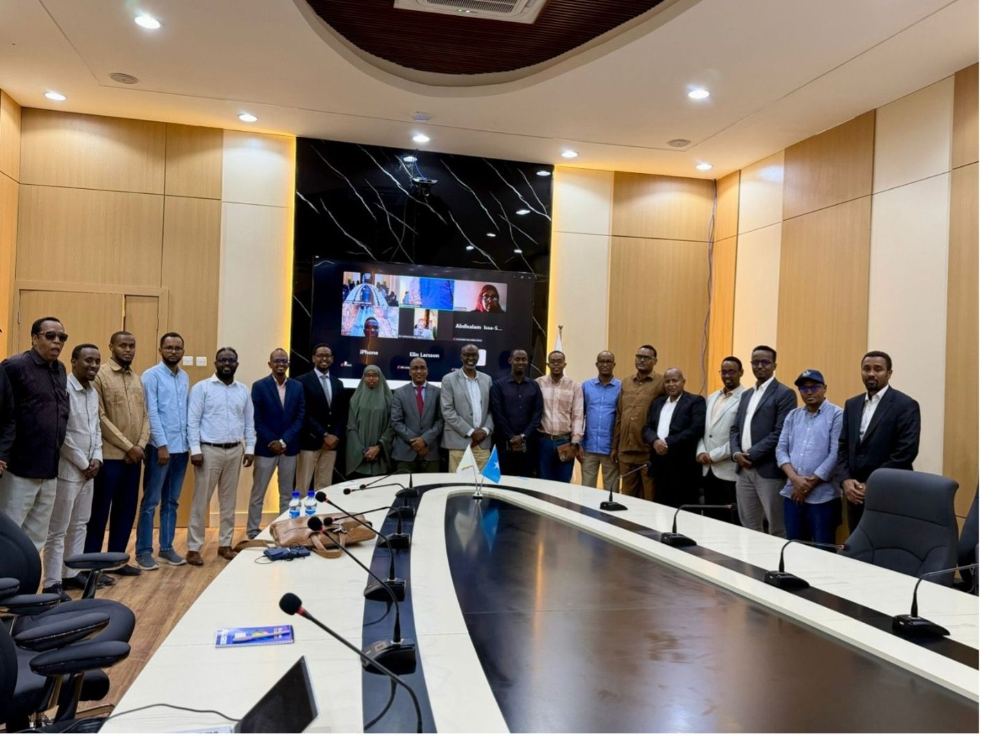 Delegates in the conference hall at Somali National University during the CURIOUS project launch, with international partners joining on screen