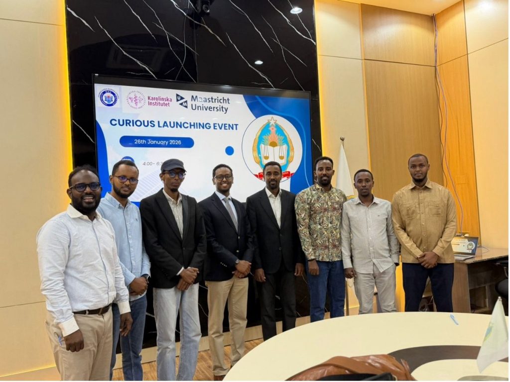 Participants standing together in front of the CURIOUS Launching Event banner at Somali National University in Mogadishu